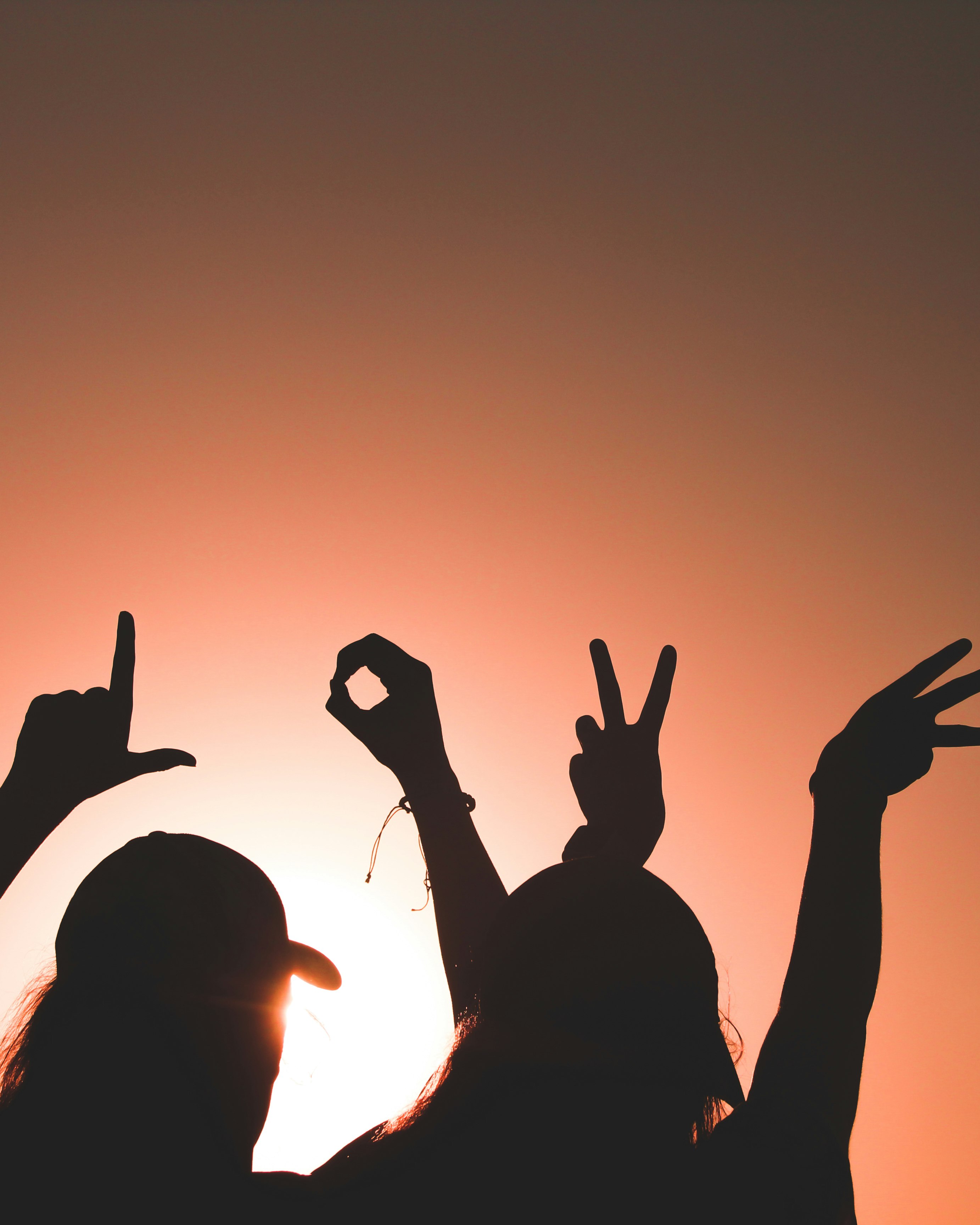 silhouette of 2 person raising hands